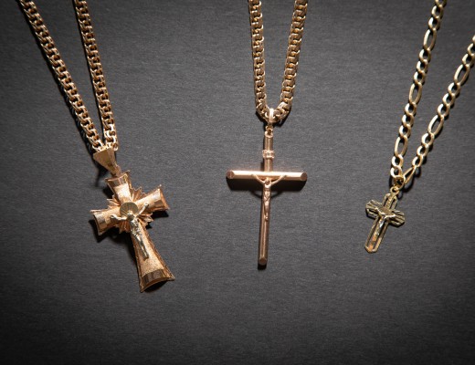 Golden cross necklace on the black background.