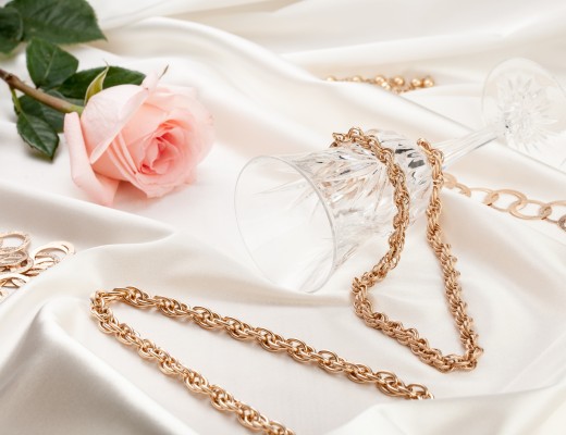 Gold jewelry, pink rose, wine glass