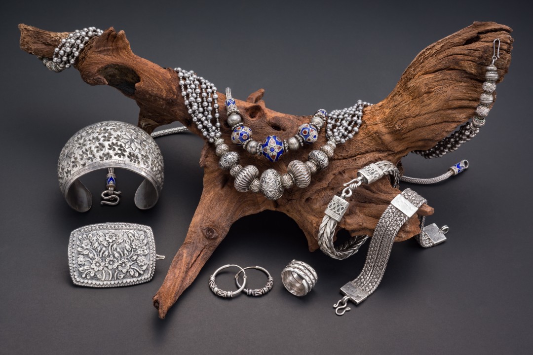 Collection of antique traditional silver jewelry on old wood and black paper