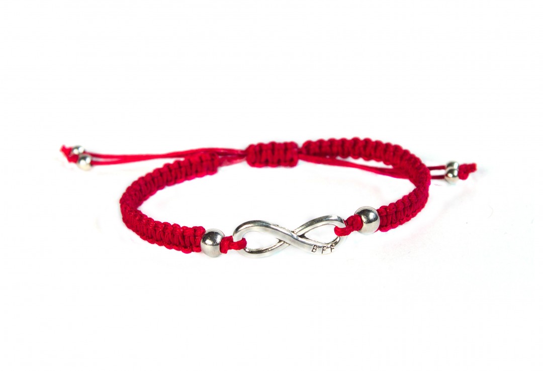 red thread bracelet with infinity on white background, handmade, friendship bracelet