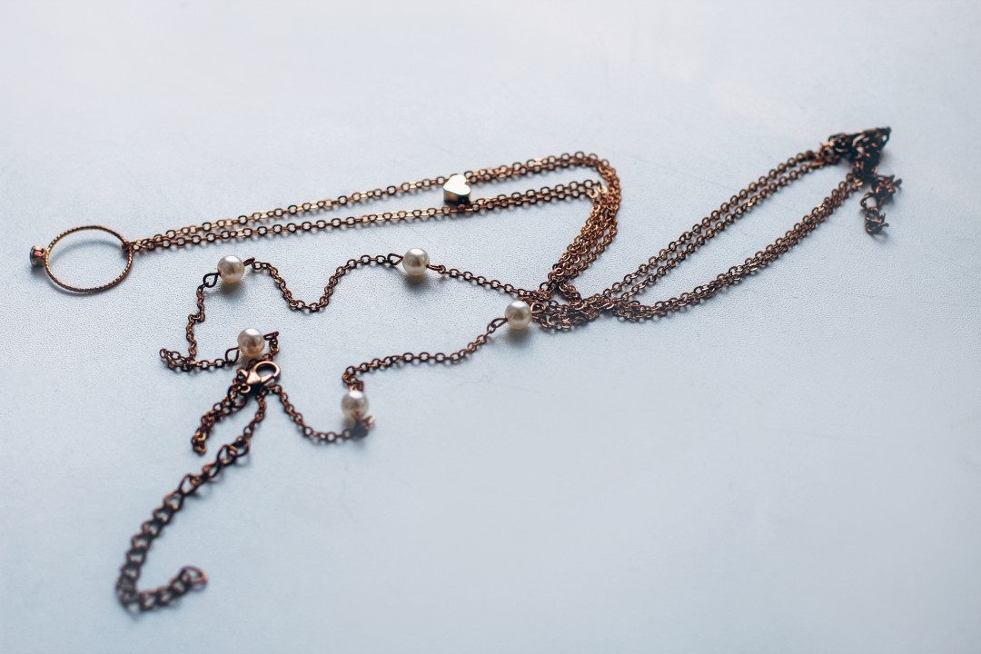 cheap jewelry chain bracelet and ring blackened from water on white background